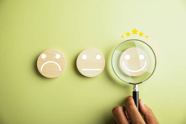 istock Magnifier in hand focuses on selected happy smiley face icon 1503645395