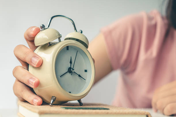 istock White alarm clock with five minutes to twelve o'clock, retro clock. 1503664115