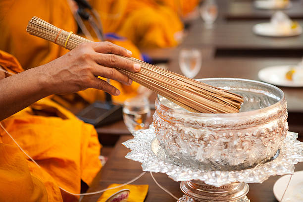 Buddhist monks, bowl with a candle and holy water inside