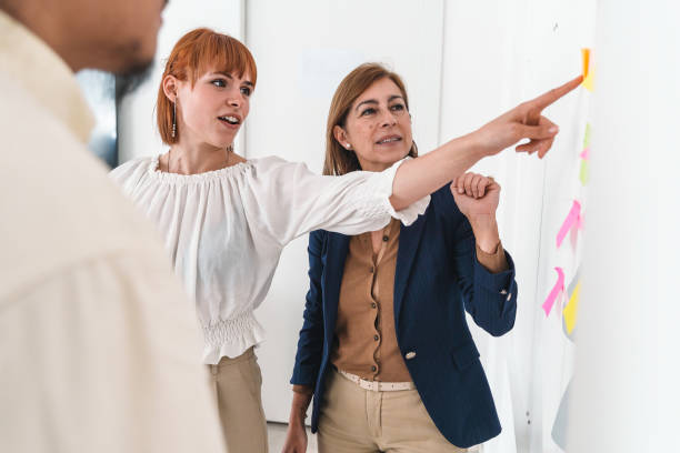 istock Young woman presenting project to colleagues in white office 1503707564