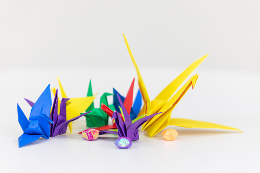 Colorful paper cranes on a white background.