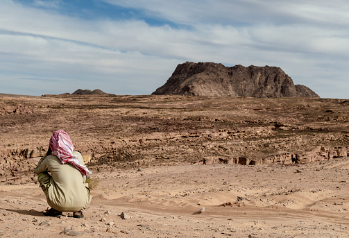 lonely bedouin sits and waits in the desert in egypt nature landscape