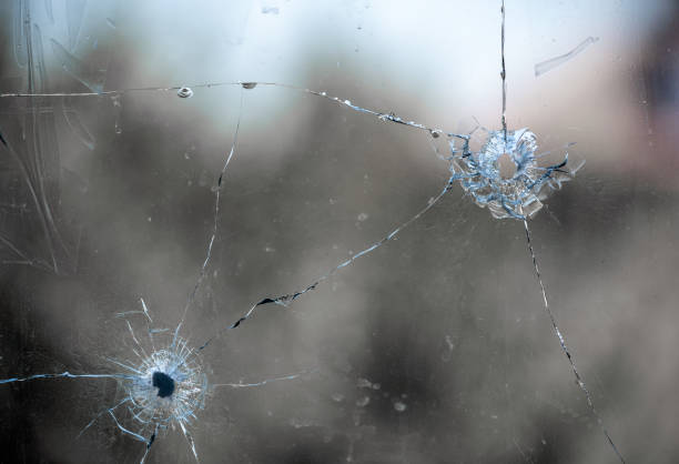 istock bullet hole in cracked window glass 1503728365