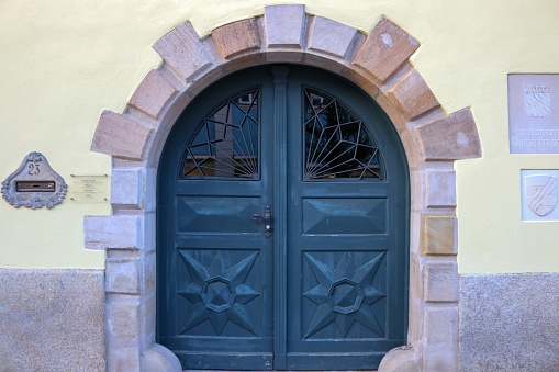 A beautiful old wooden arched door framed with granite masonry in Germany