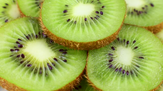 Bright green fresh kiwi slices rotation close up