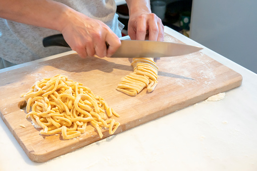 Woman's hand cutting natural homemade pasta