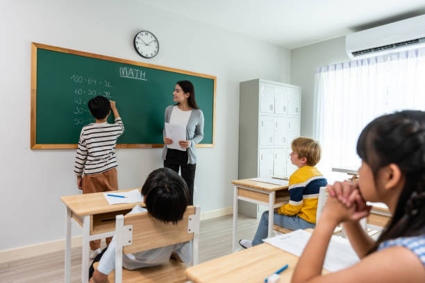istock Group of student learn with teacher in classroom at elementary school. Attractive beautiful female instructor master explain and educate young children with happiness and fun activity at kindergarten. 1503823346