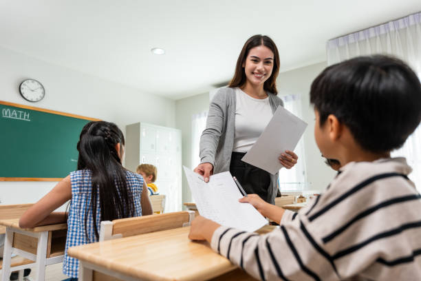 istock Group of student learn with teacher in classroom at elementary school. Attractive beautiful female instructor master explain and educate young children with happiness and fun activity at kindergarten. 1503823347
