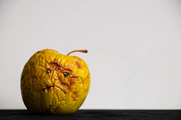 A sad apple stabbed with a knife.