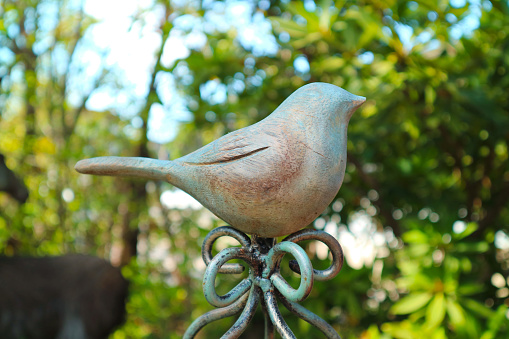 Closeup of Wooden Perching Bird Figurine in the Garden
