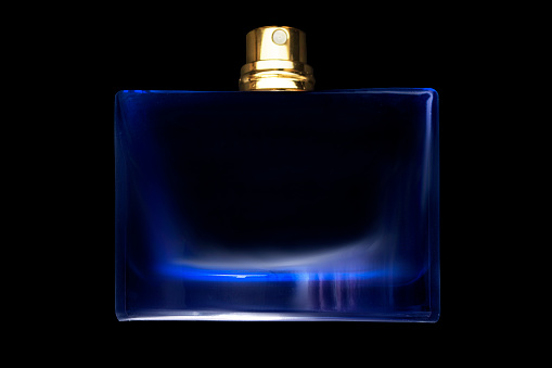 Perfume blue glass bottle isolated on white background with sharp shadow. Beauty, fashion. Top view.