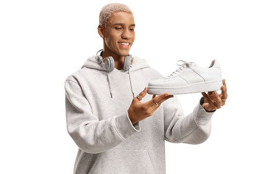 African american young man holding a new white sneaker isolated on white background