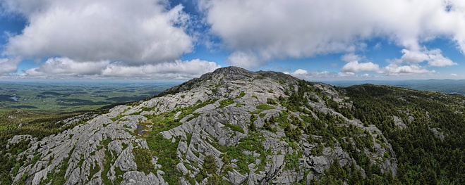 Wide angle aerial panorama view of the iconic bare rocky summit of Mt. Monadnock in southern New Hampshire. Drone photo of New England mountain peak in summer.