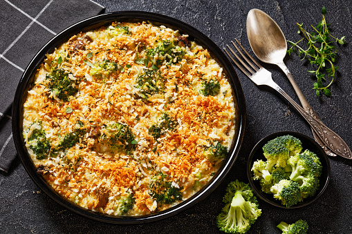 Chicken, Broccoli and mushrooms creamy Casserole topped with panko breadcrumbs in baking dish on dark concrete table