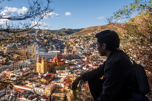 Man enjoying the vibrant cityscape of Guanajuato, Mexico, surrounded by nature and iconic landmarks