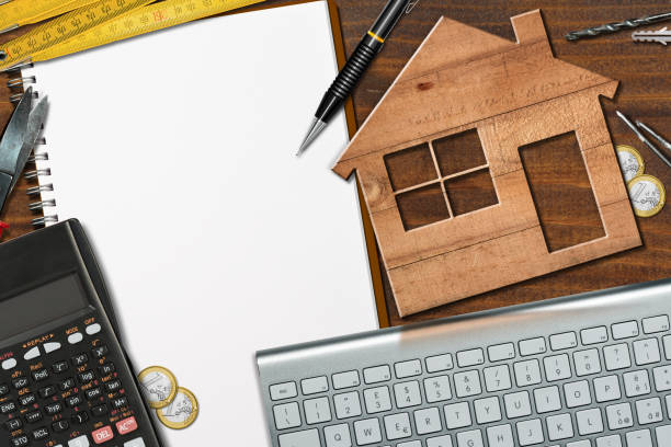 istock Small Wooden Model House on a Desk with Blank Note Book 1503883998