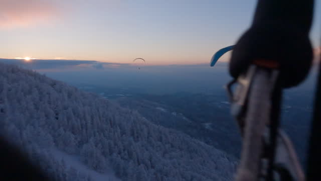 POV paragliding looking down at snowy landscape