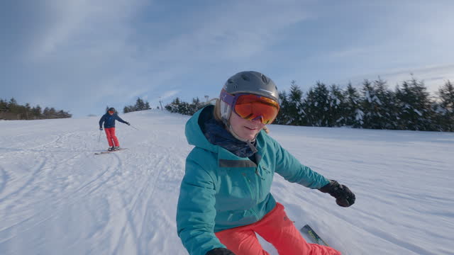 Two skiers descend alpine piste
