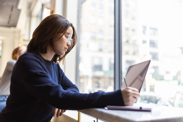 istock Studious in Soho: Asian Female Student Utilizes Laptop for Exam Preparation 1503900315