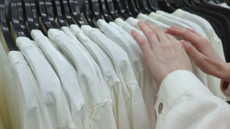 Close up of woman hands is choosing clothes in shopping center.