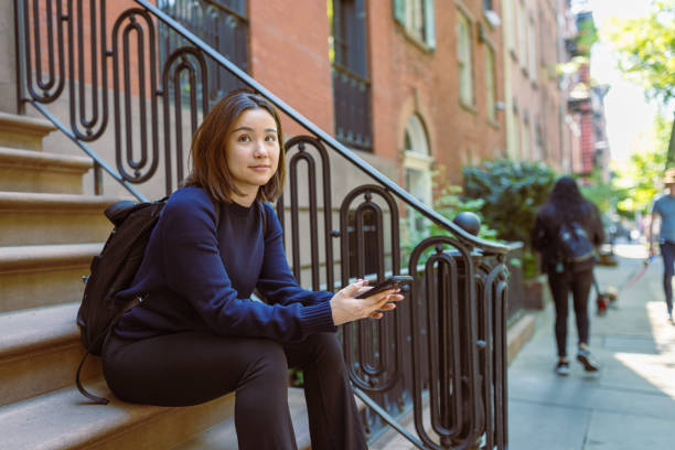 istock West Village Charm: Asian Student Embraces the Quaint Ambiance on a Doorstep 1503900571
