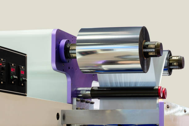 istock Automatic industrial machine for plastic packaging with light effect of products and food. shaft of an automated packaging line with plastic film in a light blue scene. product packaging concept 1503900731