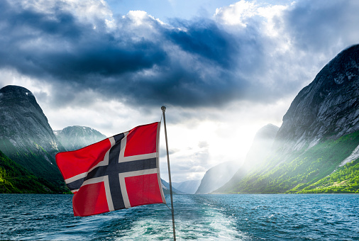 Norwegian ship flag on a ship in a fjord in Norway