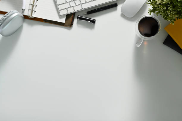 istock Top view white office desk with headphone, notebook, coffee cup and keyboard. Copy space for your text. 1503913580