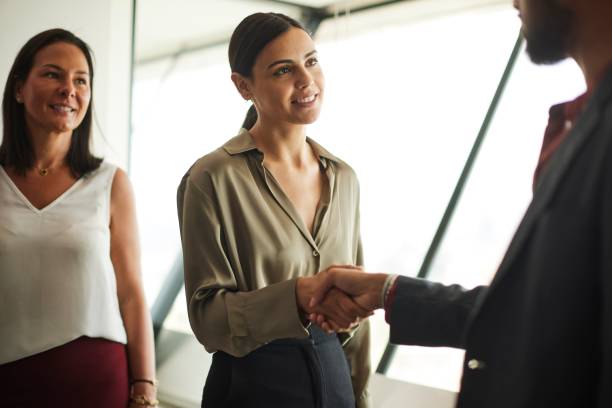 istock Business Partnership: Over-the-Shoulder View of a Handshake with Observing Partner. 1503914127