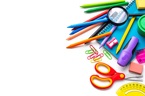 Group of multicolored school or office supplies isolated on white background. The composition is at the right of an horizontal frame leaving useful copy space for text and/or logo at the left. High resolution 42Mp studio digital capture taken with Sony A7rII and Sony FE 90mm f2.8 macro G OSS lens