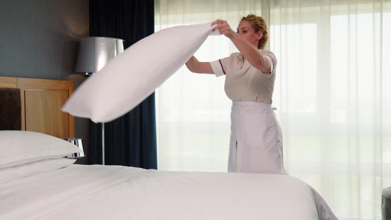 Hotel maid putting clean pillow case