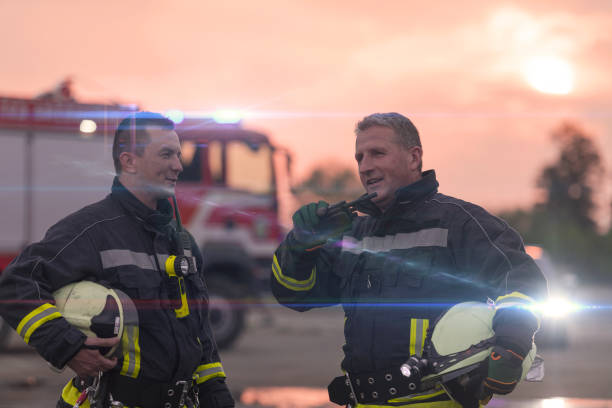 strażak używający walkie talkie w akcji ratownictwa samochodowego wóz strażacki i zespół strażacki w tle. - car fire accident land vehicle zdjęcia i obrazy z banku zdjęć