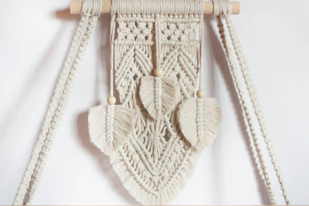istock Wall decor in ecological boho, Scandinavian style. Wooden shelf in the macrame technique. Interior design, close-up. Macrame decor. 1503921045