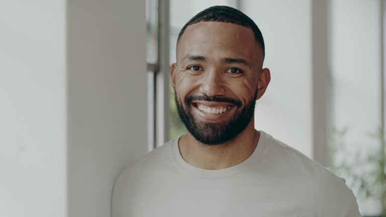 A young man is standing while looking away, then at the camera again, with copy space. Stock video