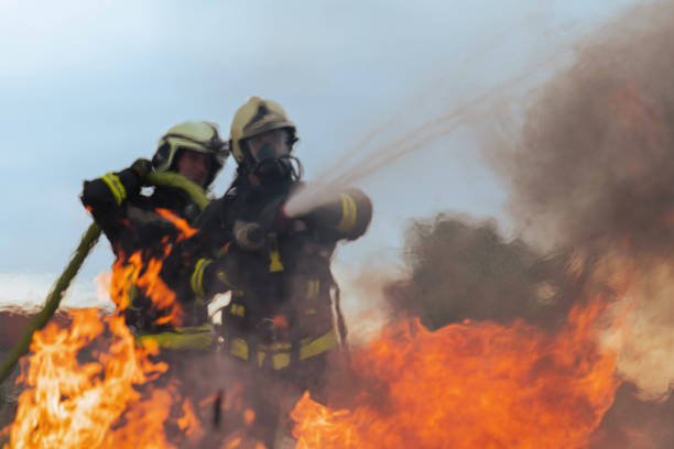 Firefighters fight the fire flame to control fire not to spreading out. Firefighter industrial and public safety concept. Traffic or car accident rescue and help action