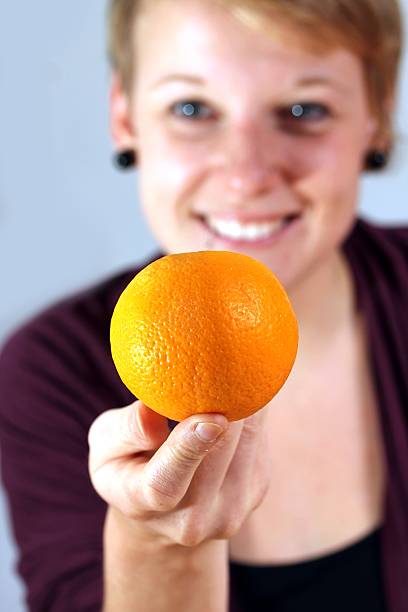 istock girl balancing an orange 150392129