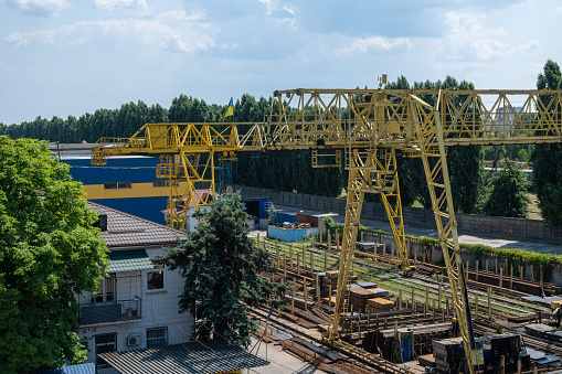 Large yellow railway crane for loading iron pipes close-up