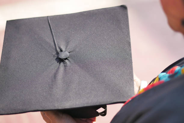 istock Student hold hats in hand during commencement success on yellow background 1503967705