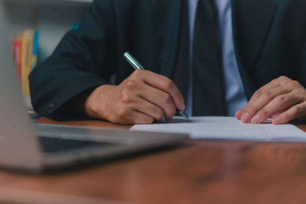 istock person document writing on paper with a pen, Man worker signing job contract, note, insurance and report concept. 1503985495