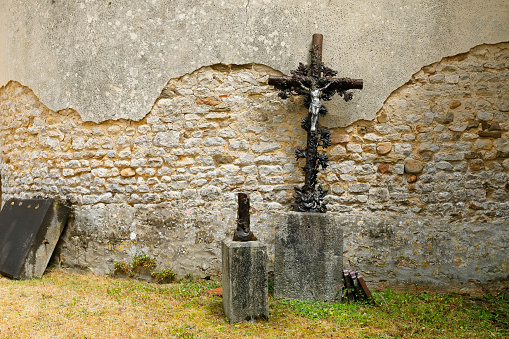 Damaged christian cross in an old cemetery in Normandy, France