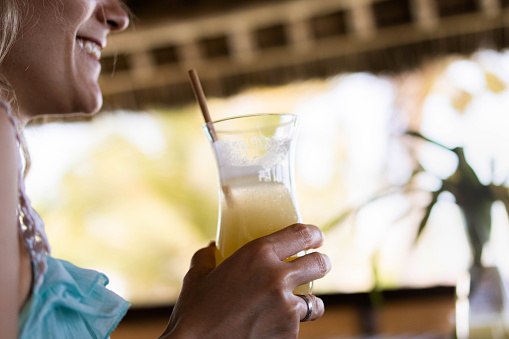 Close up of unrecognizable happy woman enjoying in her cold summer drink.