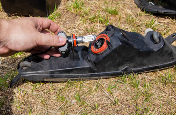 istock Replacing a burned out light bulb in a car headlight with an LED lamp. Close-up 1503992193