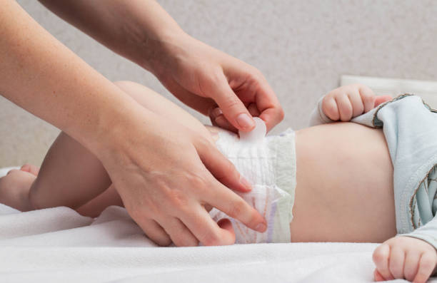 istock The mother fastens the fasteners and changes the baby's diaper, close-up. Copy space for text 1503993835