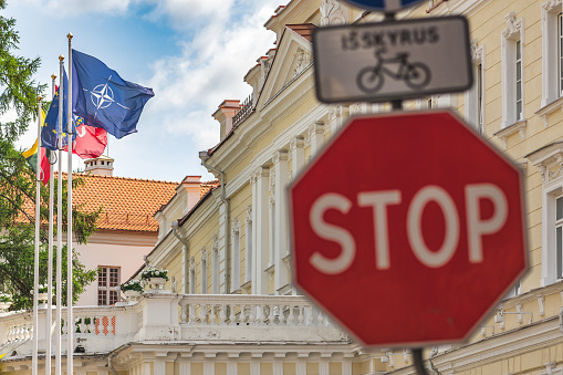 Vilnius, Lithuania - June 28 2023: Flags of NATO, North Atlantic Treaty Organization, European Union and of Lithuania during Nato summit 2023 in the centre of Vilnius, capital of Lithuania with stop sign or signal