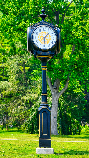 Niagara Falls, Ontario, Canada - June 17, 2023: A monument with an analog clock in a park. Niagara Falls Rotary is inscribed on the timepiece.