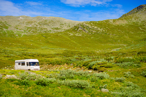 Tourism vacation and travel. Camper car in green summer mountains landscape. National tourist route Aurlandsfjellet.