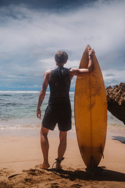 istock Surfer man standing on the beach 1504011855