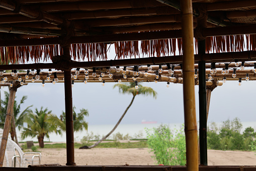 A garland of electric lights on a bamboo roof on the shore