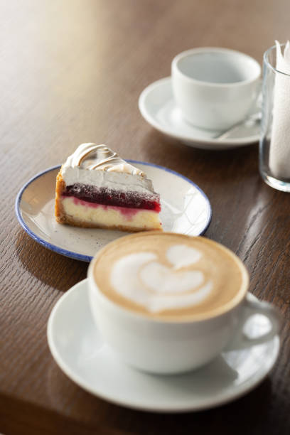 istock A cappuccino with a heart pattern, a slice of cake, a white cup on the table in a cafe. 1504015879