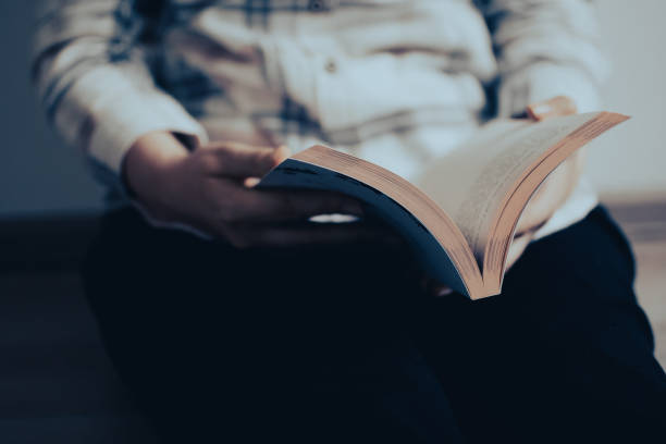istock A reader holding an old book and reading it at home 1504022000